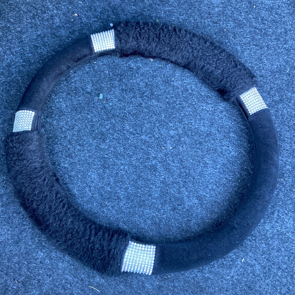 A black wheel cover that’s fits all steering wheel. It has diamonds for design.